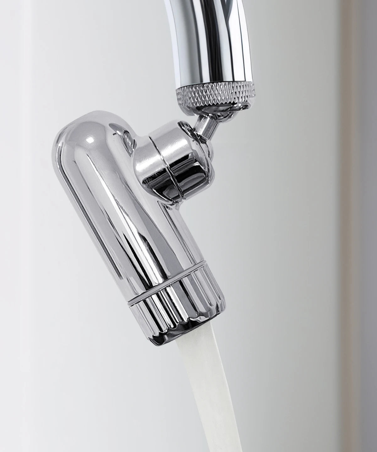 AERO Vital Wasserhahnaufsatz aus verchromtem Metall mit fließendem Wasser, montiert an einem Küchenwasserhahn in Nahaufnahme