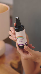 Person sitzt entspannt auf einem Sessel, hält das Rainbow Spray in der Hand und genießt den Moment in ruhiger Wohnumgebung